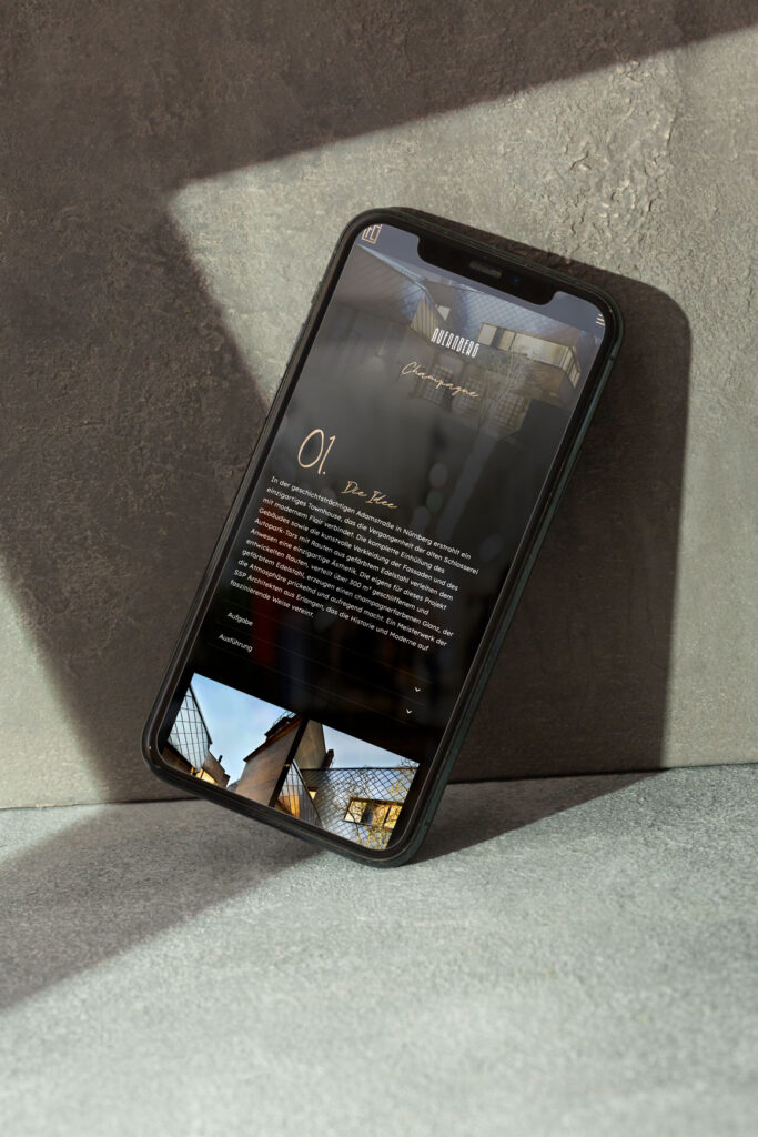 Smartphone mit Darstellung einer Website von Fleischer Metallfaszinationen in stimmungsvoller Lichtinszenierung