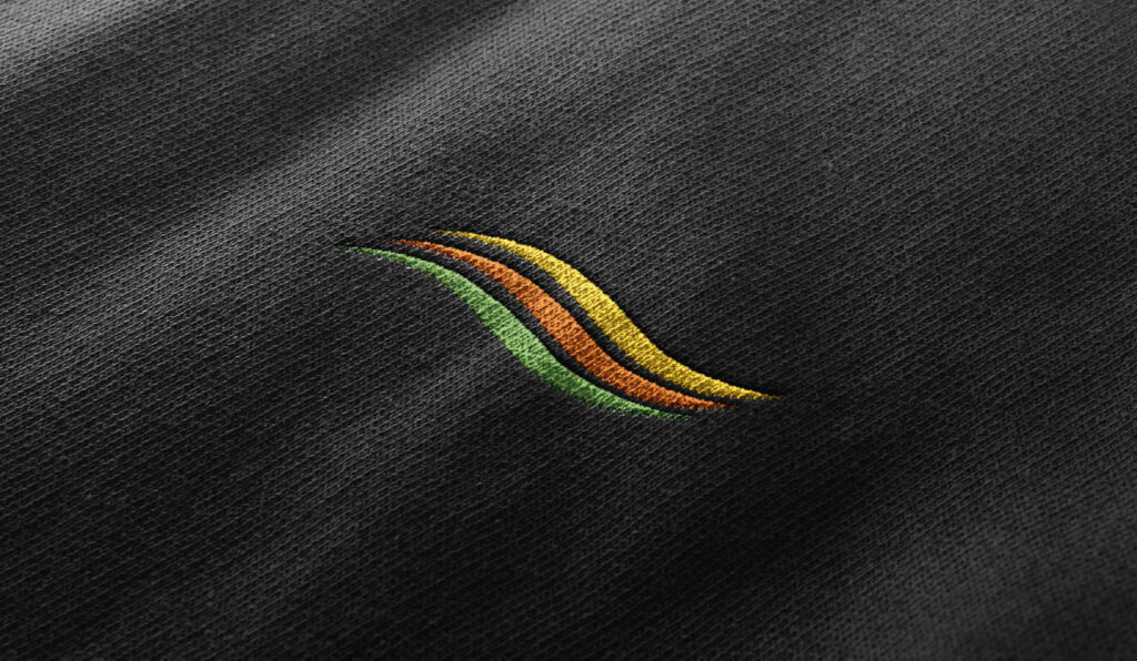 Gesticktes FRISTO Markenelement in Form einer farbigen Welle auf Textil