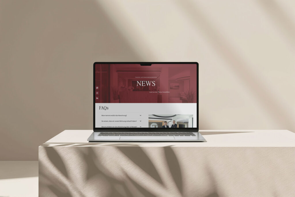 Website Mockup der Thasos Unternehmensgruppe auf Laptop mit News und FAQ Bereich für Immobilien in Augsburg und München