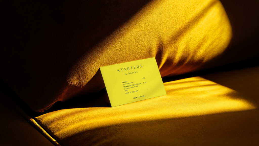 Gedruckte Speisekarte des Café Zeitgeist mit Bereich „Starters & Snacks“ auf farbigem Hintergrund