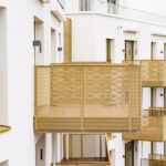 Detailansicht moderner Balkone eines Mehrfamilienhauses in Oberschleißheim bei München mit goldfarbenen Metallgeländern