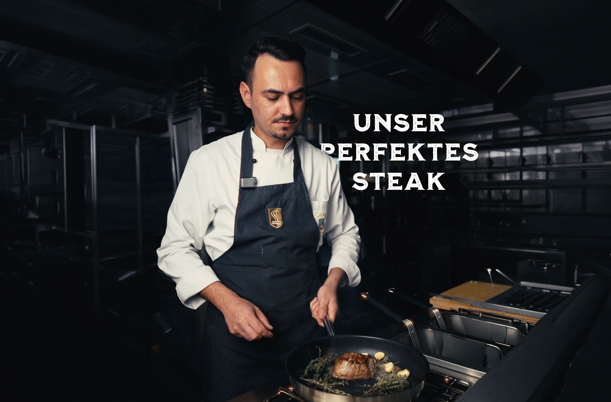 Koch beim Zubereiten eines Steaks im Brauereigasthof Laupheimer mit Schriftzug 'Unser perfektes Steak'